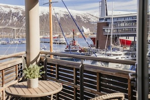 Un balcon avec vue sur une marina, des bateaux et un pont en arrière-plan.