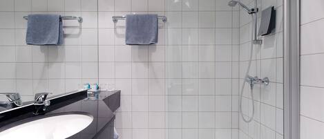 Une salle de bain moderne avec un lavabo noir, deux serviettes, une douche et un miroir.