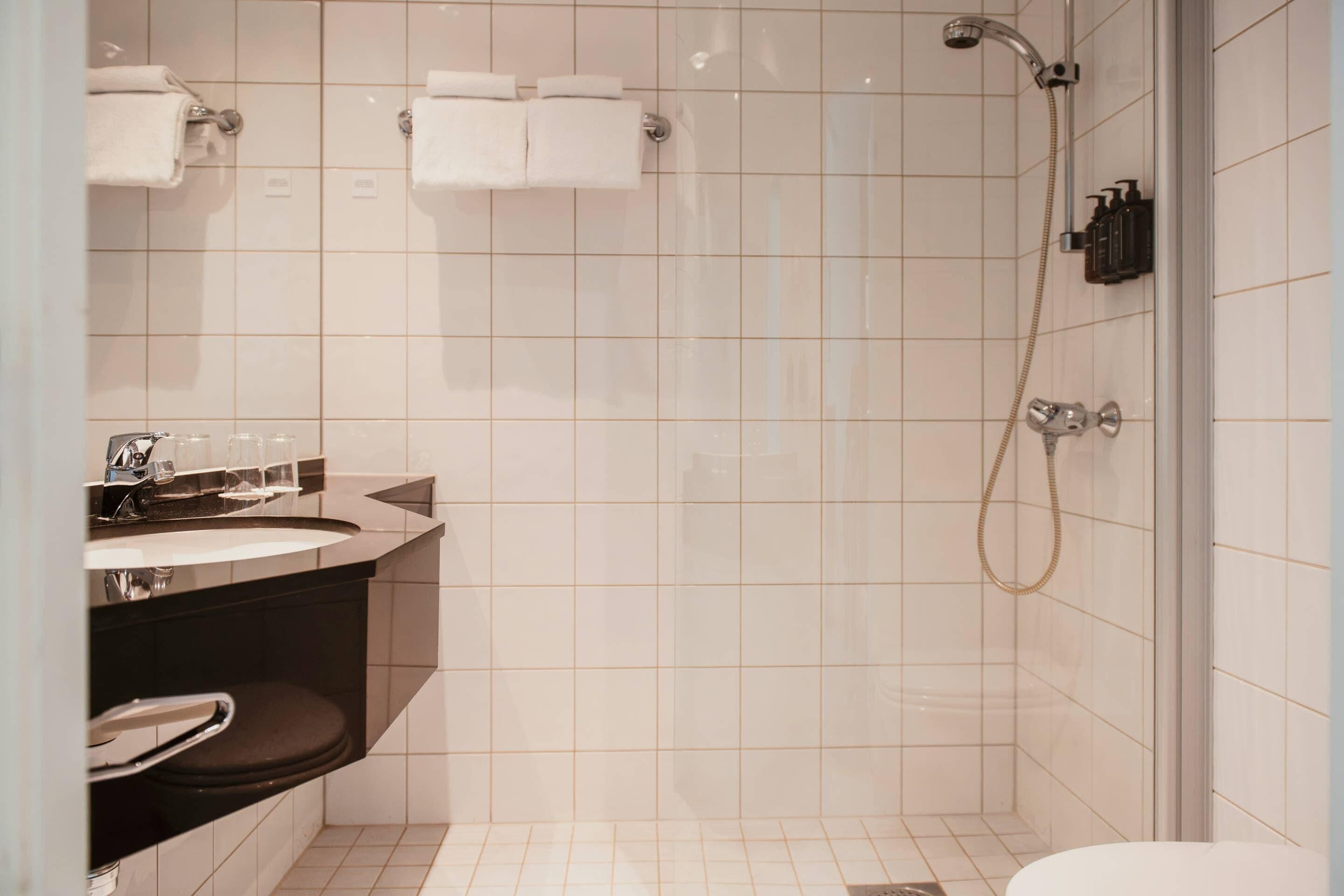 Une salle de bain moderne avec un lavabo, un miroir et une douche.