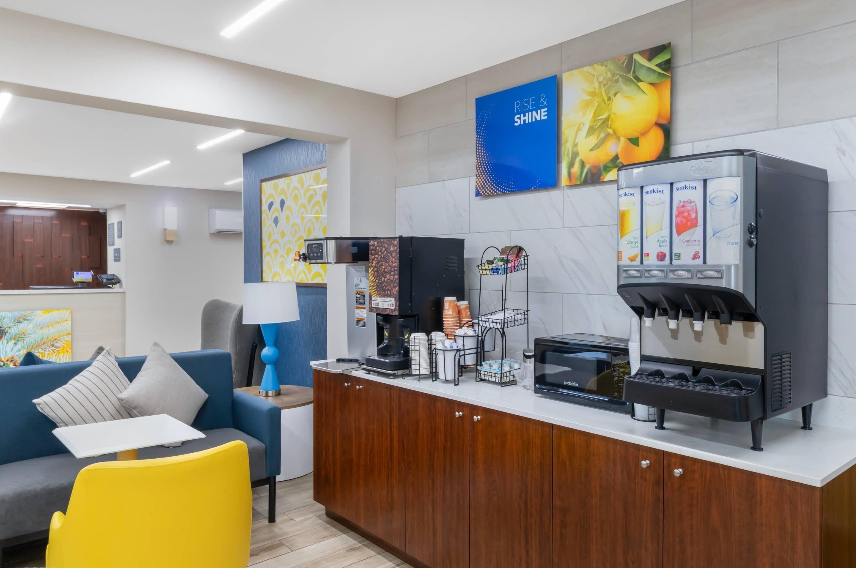 Une petite cuisine moderne équipée d’une machine à café, d’un four à micro-ondes et d’un distributeur d’eau.