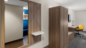 A modern room with a wooden wardrobe, a white shelf, and a yellow office chair. - Holiday Inn Express Hotel & Suites Danbury - I-84 by IHG (Danbury)