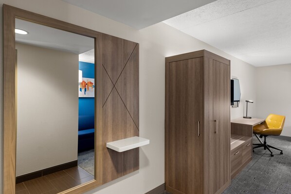 A modern room with a wooden wardrobe, a white shelf, and a yellow office chair. - Holiday Inn Express Hotel & Suites Danbury - I-84 by IHG (Danbury)