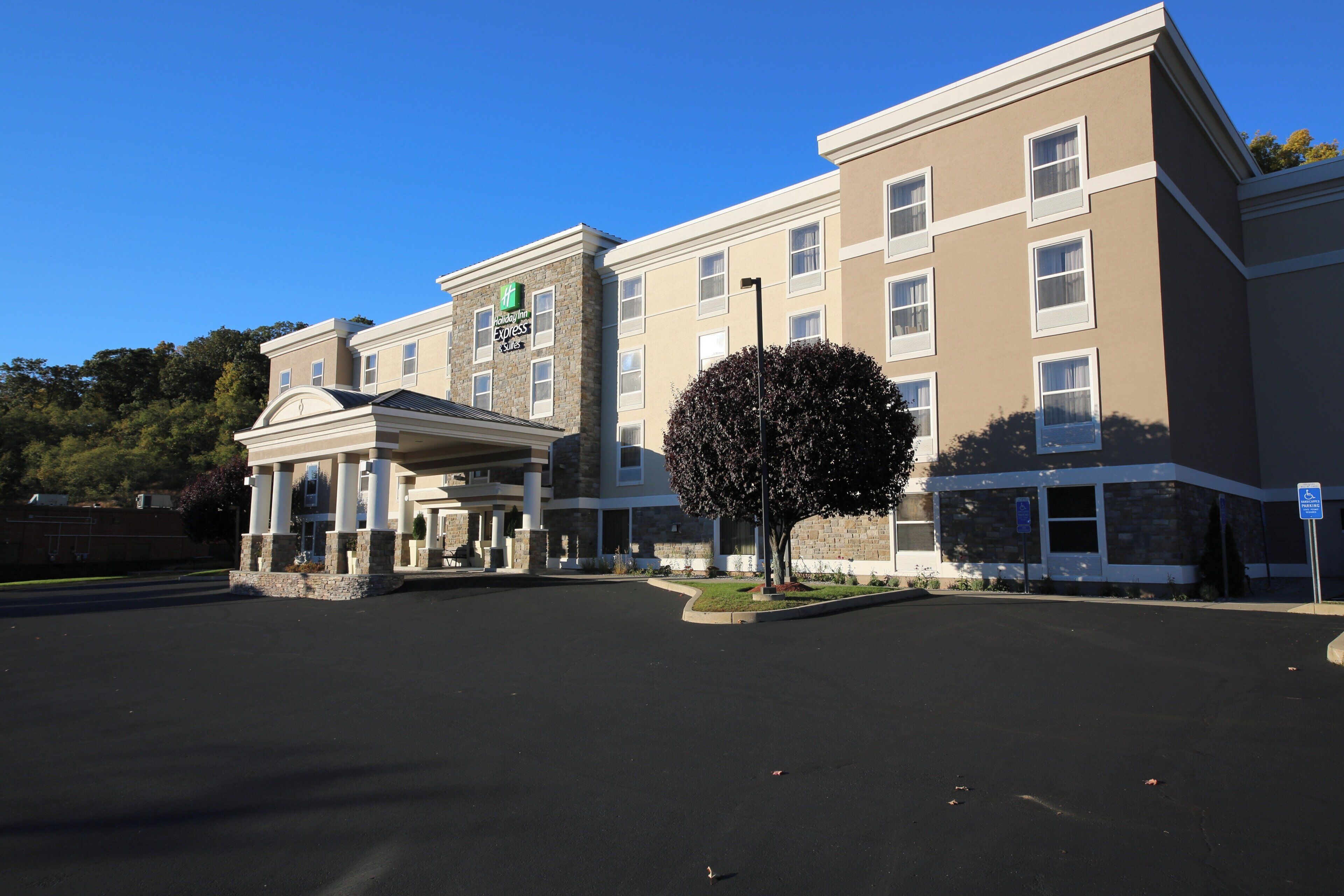 Un hotel Holiday Inn Express & Suites con entrada techada y estacionamiento.