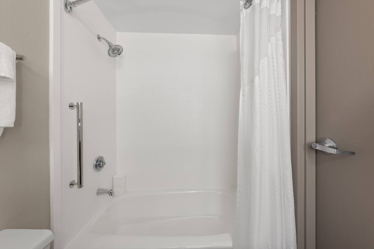 Ein Badezimmer mit Dusche, Toilette und Badewanne.