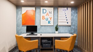 A modern office space with a desk, two chairs, a printer, and framed artwork on the wall. - Holiday Inn Express Hotel & Suites Danbury - I-84 by IHG (Danbury)