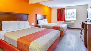 A hotel room with two beds, a TV, and a window with curtains. - Motel 6 Pendleton, OR - West (Pendleton)