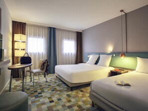 A hotel room with two beds, a desk, a chair, and a lamp. - Hotel Mercure Marne la vallée Bussy St. Georges (Bussy-Saint-Georges)