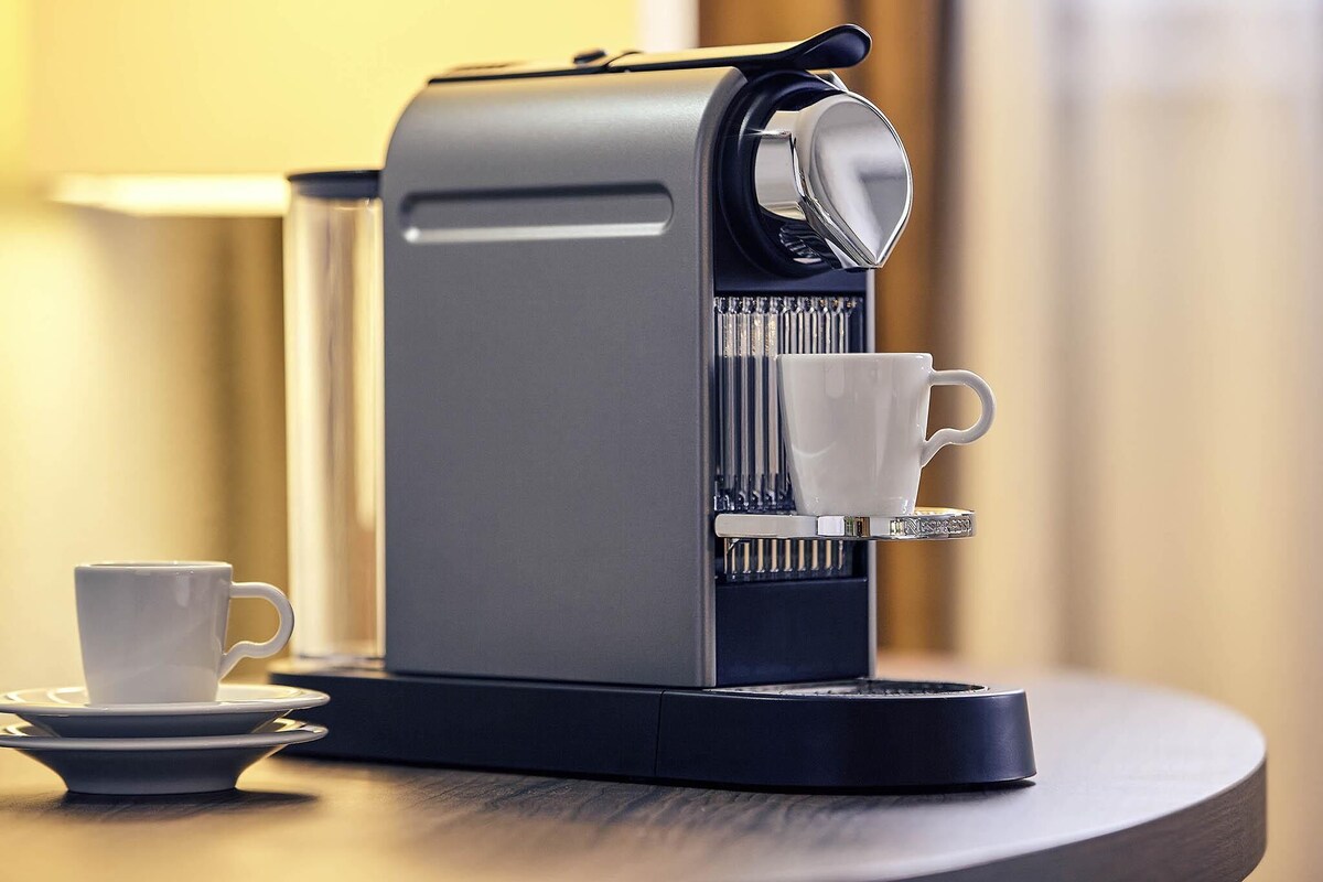 A coffee machine with a cup and saucer on a table.