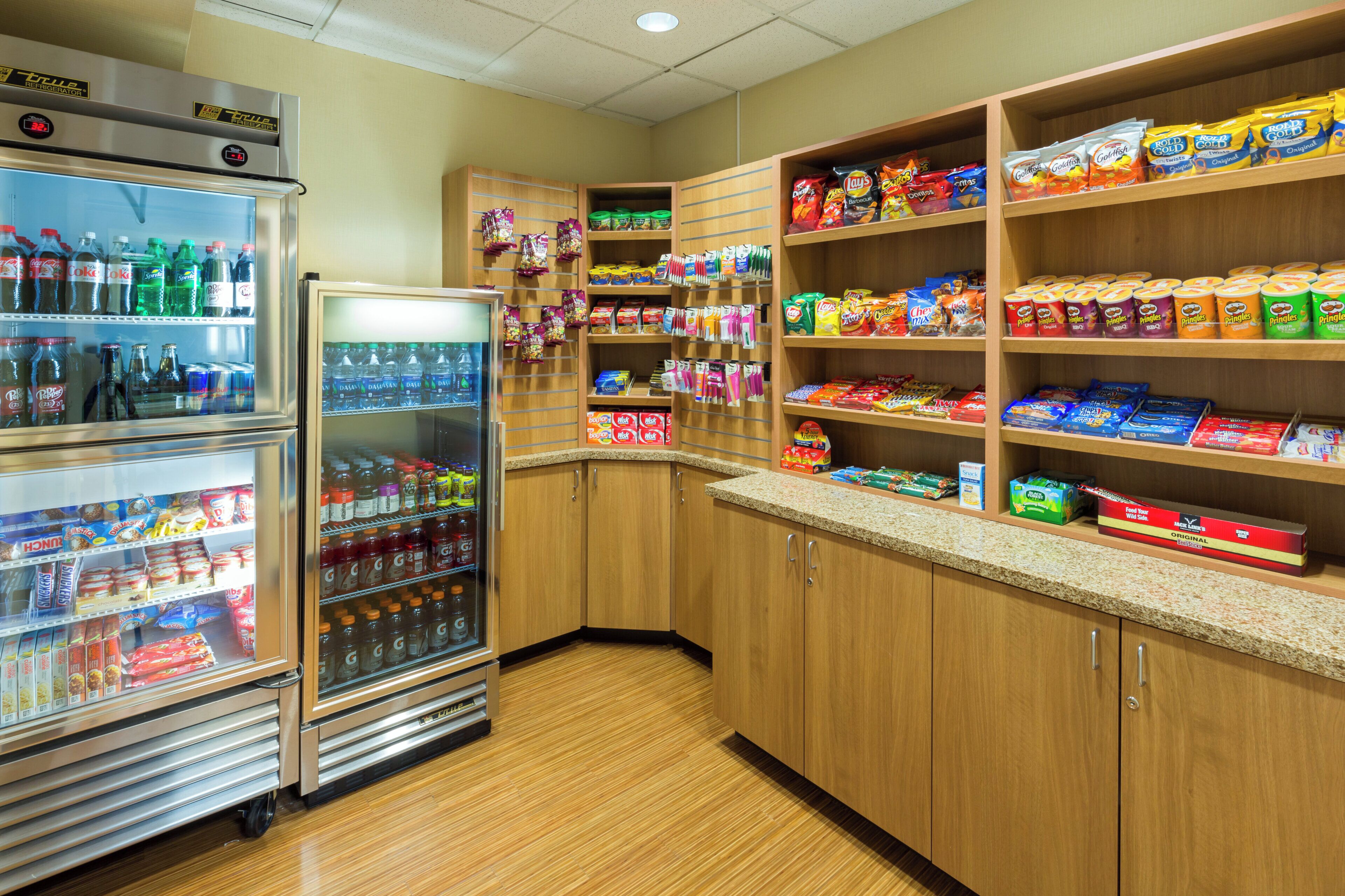 A snack and beverage vending area with multiple shelves stocked with various snacks and drinks.