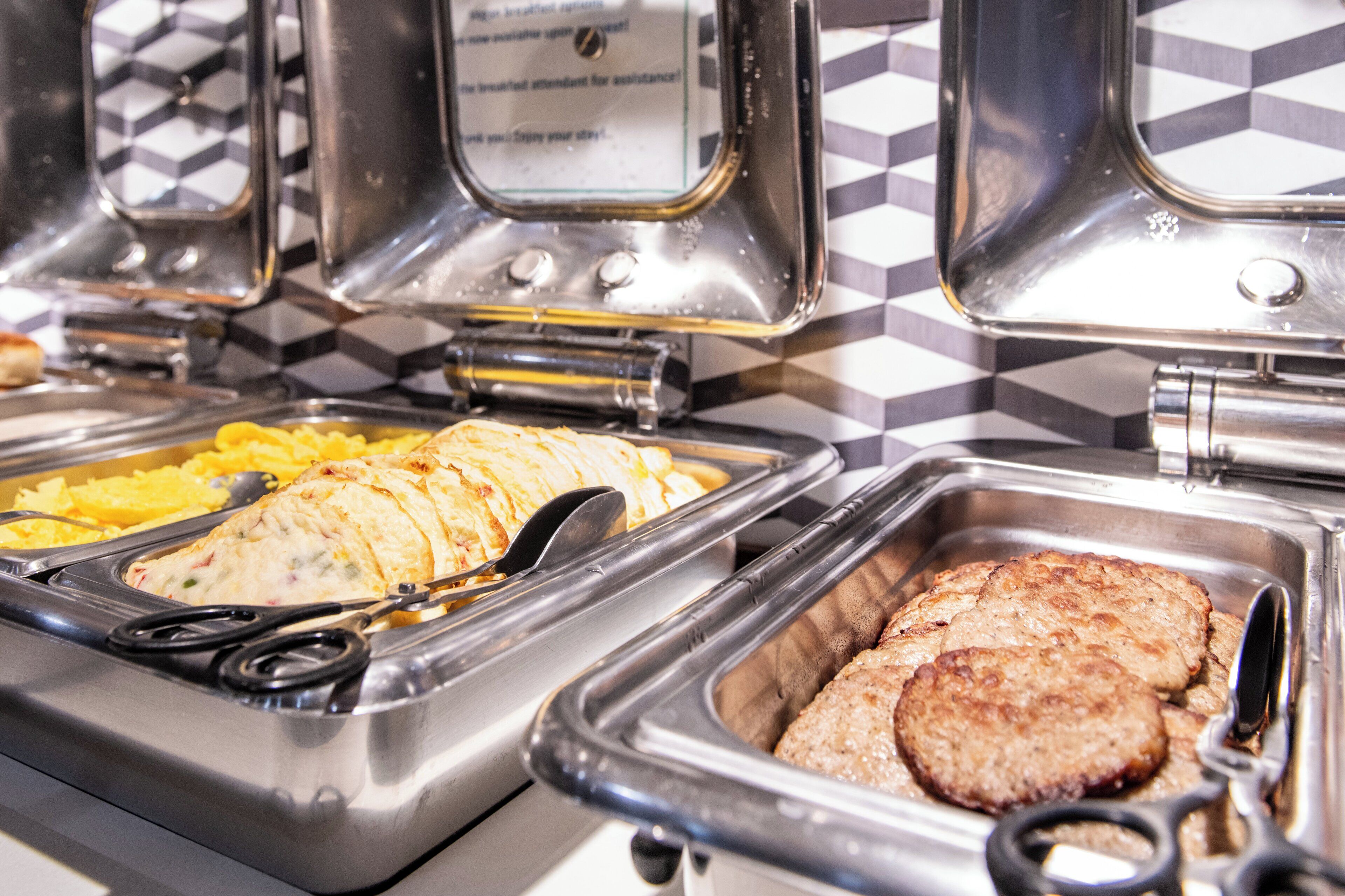 Un bufé con diversos alimentos, incluyendo carnes en rodajas y verduras.