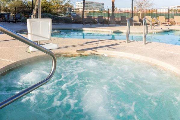 Una piscina al aire libre, sillones reclinables de piscina