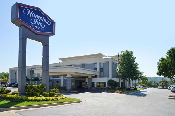 Un hôtel Hampton Inn by Hilton au design moderne, doté d’une entrée accueillante et d’une allée bordée de verdure.