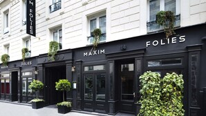 A building facade with the name "MAXIM FOLIES" prominently displayed.