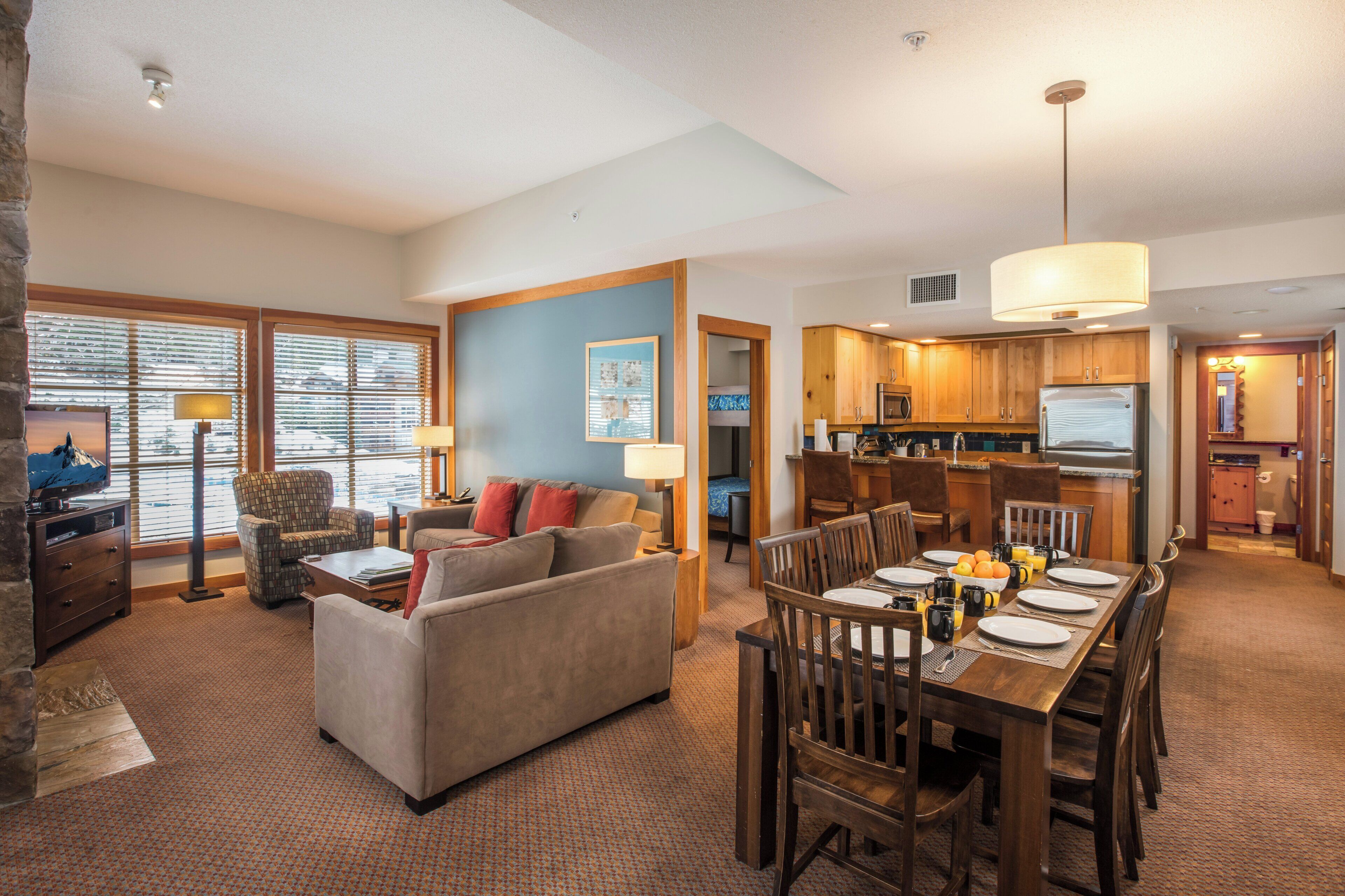 A spacious living area with a sofa, dining table, and kitchen in the background.