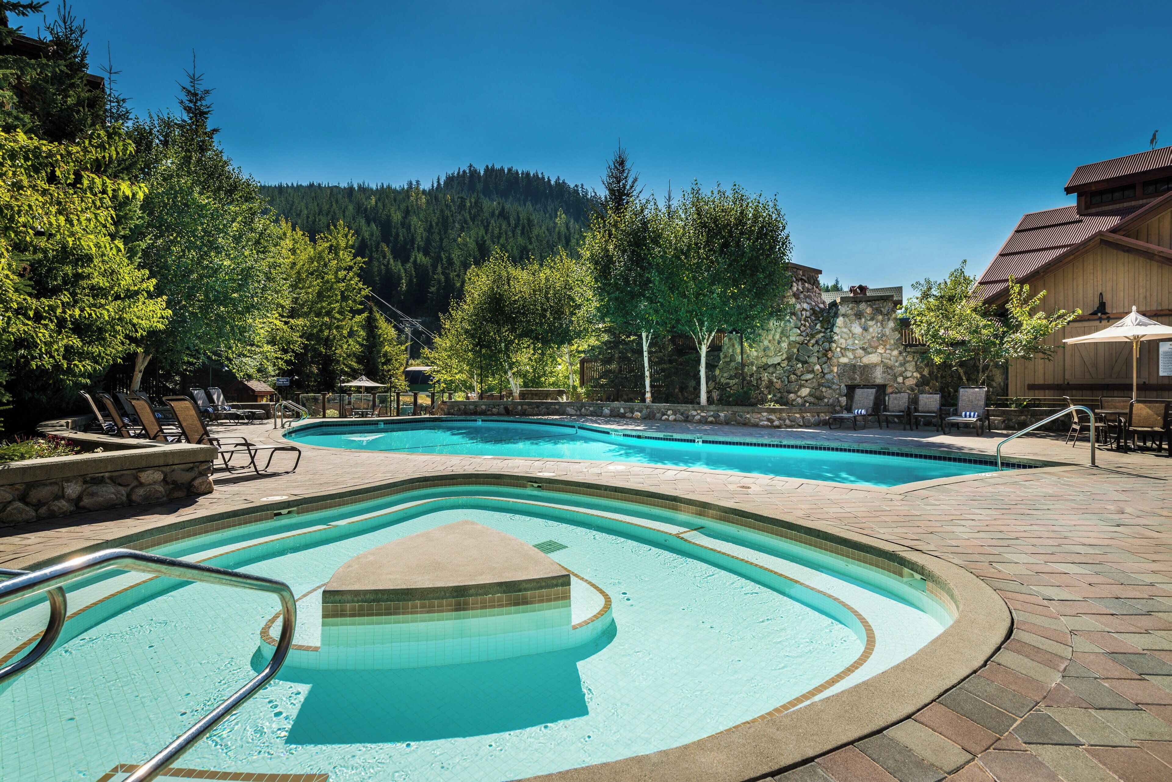 Een buitenzwembad, ligstoelen bij het zwembad