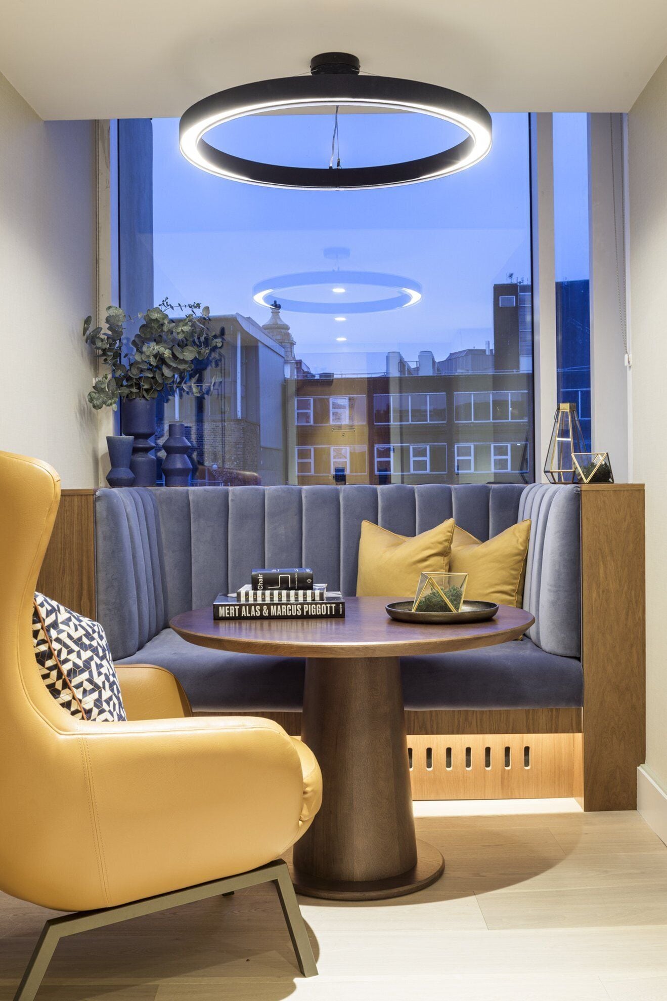 A modern room with a sofa, a table, and a unique ceiling light fixture.