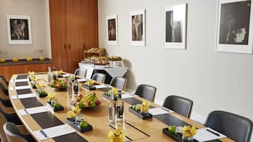 A conference room with a long table, chairs, and framed pictures on the wall.