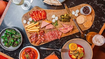 A charcuterie board with various meats, cheeses, and crackers on a wooden board.