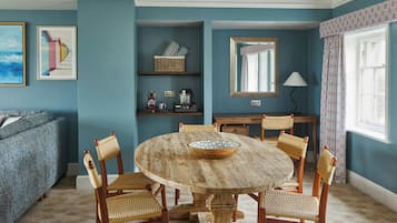 Un comedor con una mesa redonda de madera, seis sillas de fibra natural y un bol en el centro.