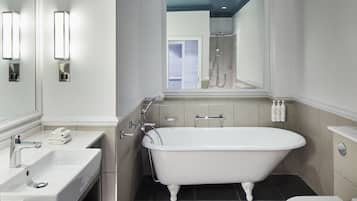Un baño con una bañera independiente, un lavabo y un inodoro.