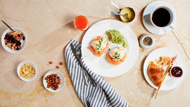 Un desayuno con diferentes alimentos y bebidas sobre una mesa de mármol.