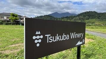 Señal para la bodega Tsukuba con un símbolo de estacionamiento.
