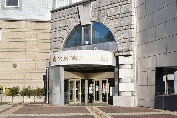A hotel entrance with a modern design, featuring a curved facade and large glass doors. - Hotel Nikko Tsukuba (Tsukuba)