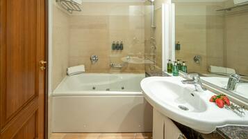 Un baño moderno con ducha envuelta en vidrio, una bañera independiente y un tocador con lavabo y espejo.