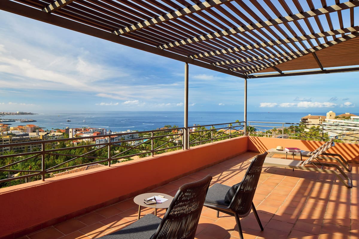A terrace with a view of the sea, featuring a table and two chairs.
