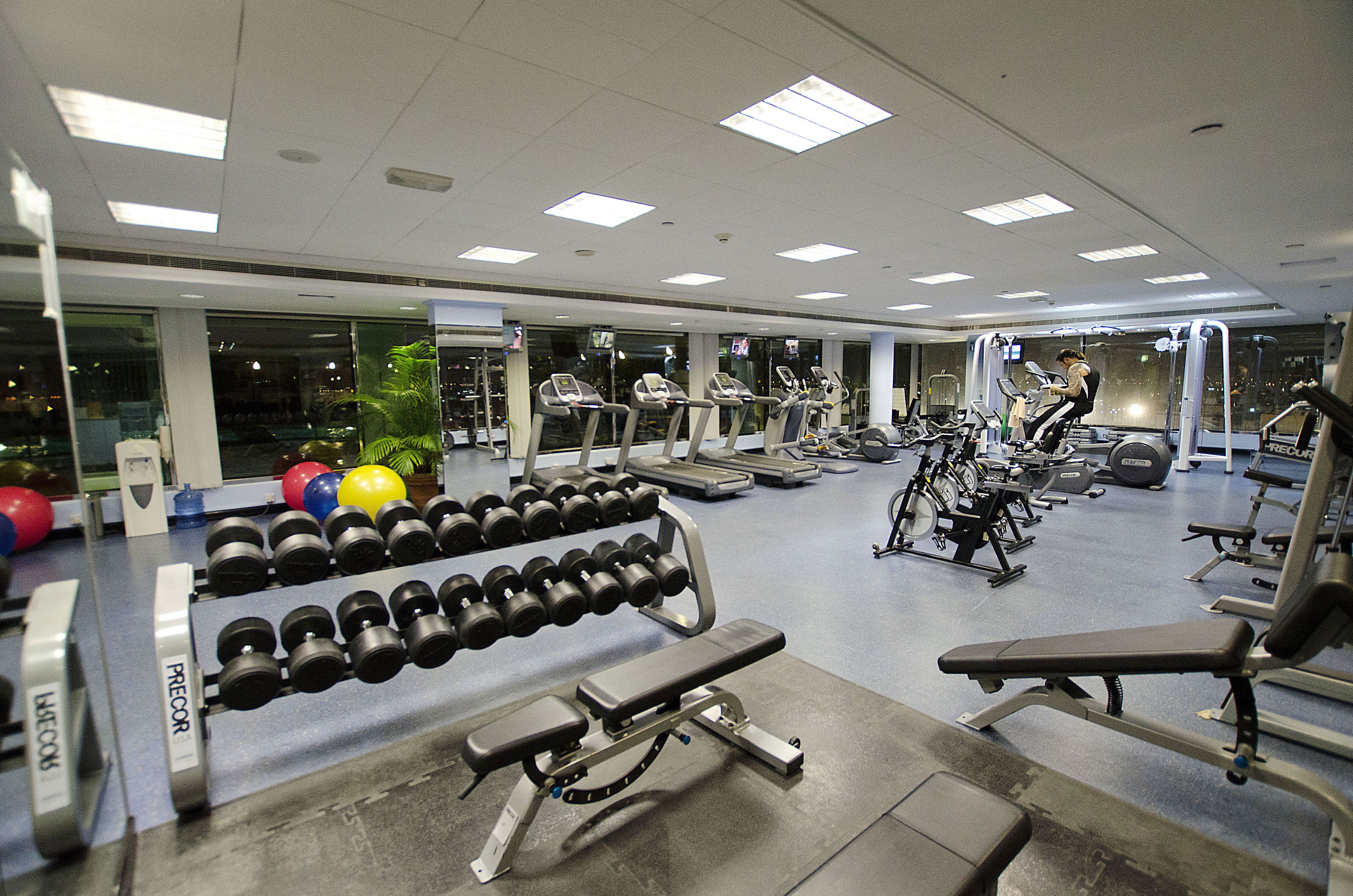 A gym with treadmills, dumbbells, and weight machines.