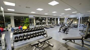 A gym with treadmills, dumbbells, and weight machines.