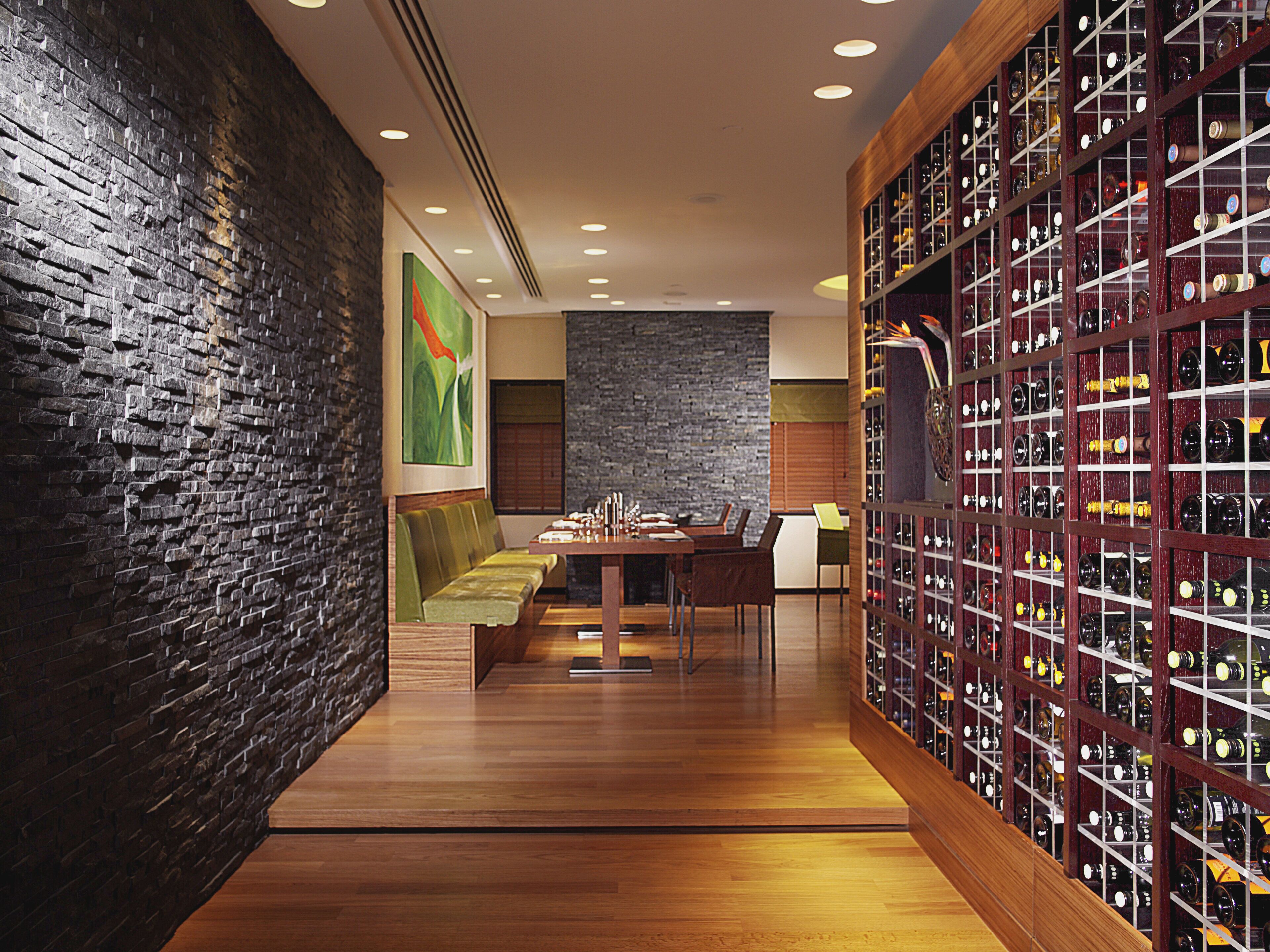 Un restaurante con pared de ladrillo, muebles de madera y una estantería para vino.