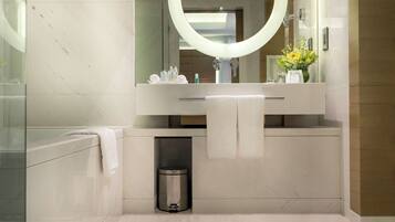 A modern bathroom with a large mirror, two pendant lights, and a round mirror on the wall.