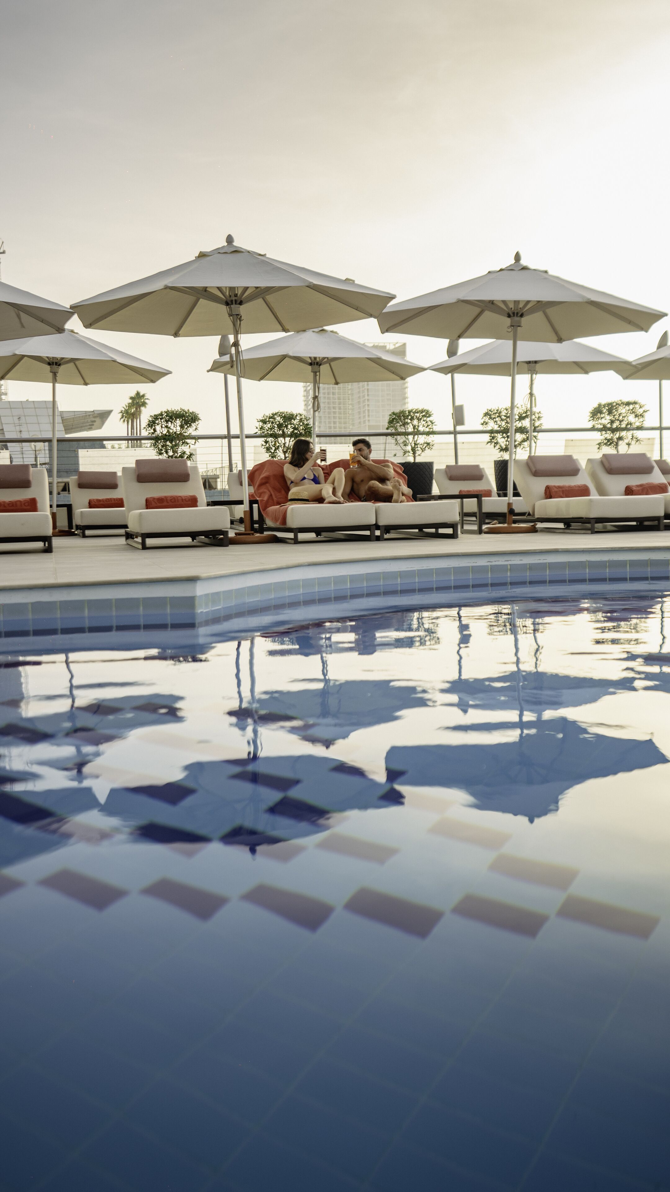 Ein Poolbereich mit Liegestühlen und Sonnenschirmen.