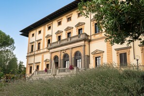 A large, multi-story building with a classical architectural style, featuring a central balcony and arched windows. - Villa Pitiana (Reggello)