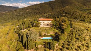 A large, historic building surrounded by lush gardens and a swimming pool. - Villa Pitiana (Reggello)