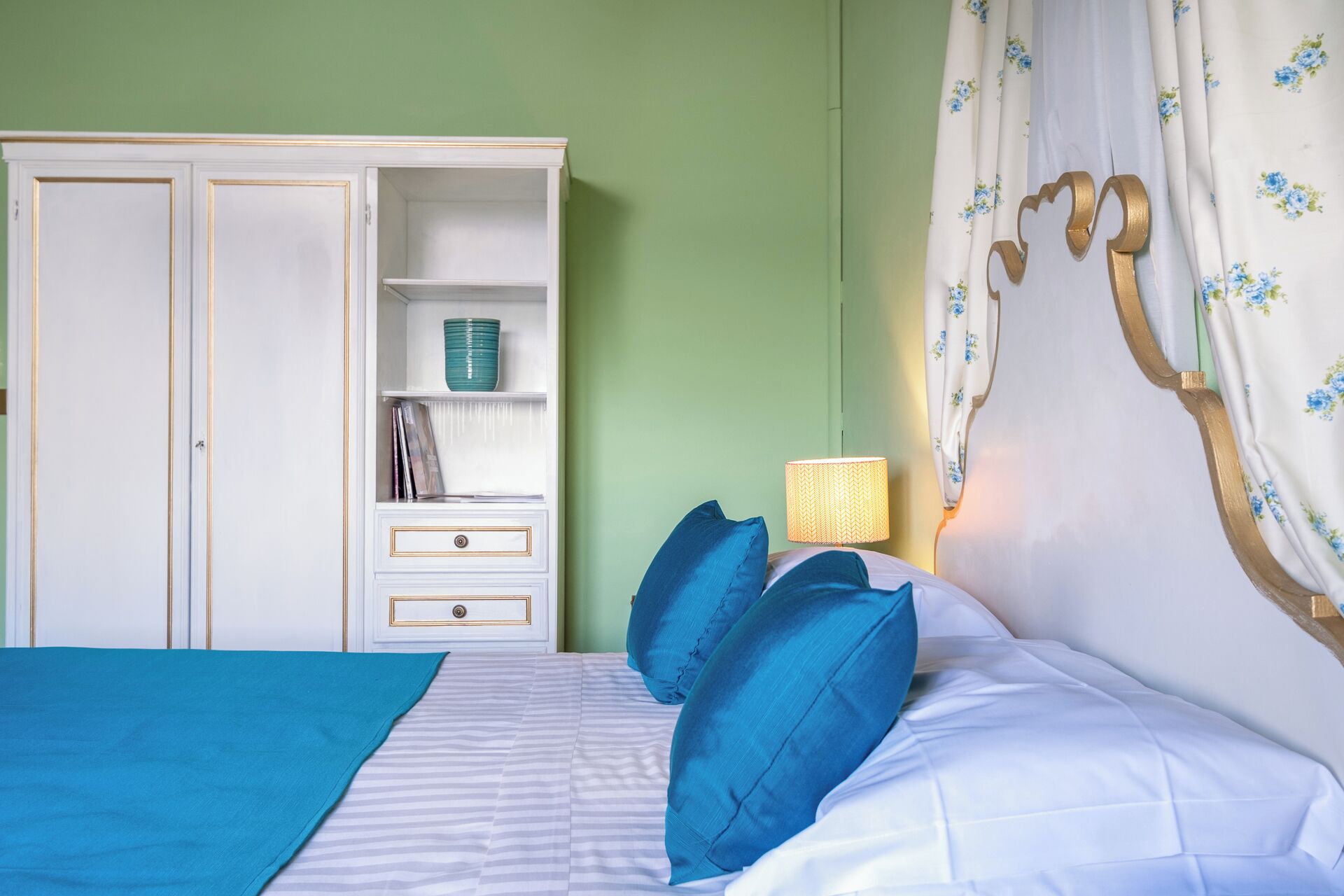 Ein Schlafzimmer mit Bett, Nachttisch, Kleiderschrank und Lampe.