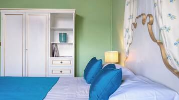 Ein Schlafzimmer mit Bett, Nachttisch, Kleiderschrank und Lampe.