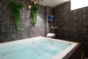 A modern bathroom with a bathtub, dark brick walls, and decorative plants. - Casa Marina Sosua, Trademark by Wyndham Resort (Sosúa)