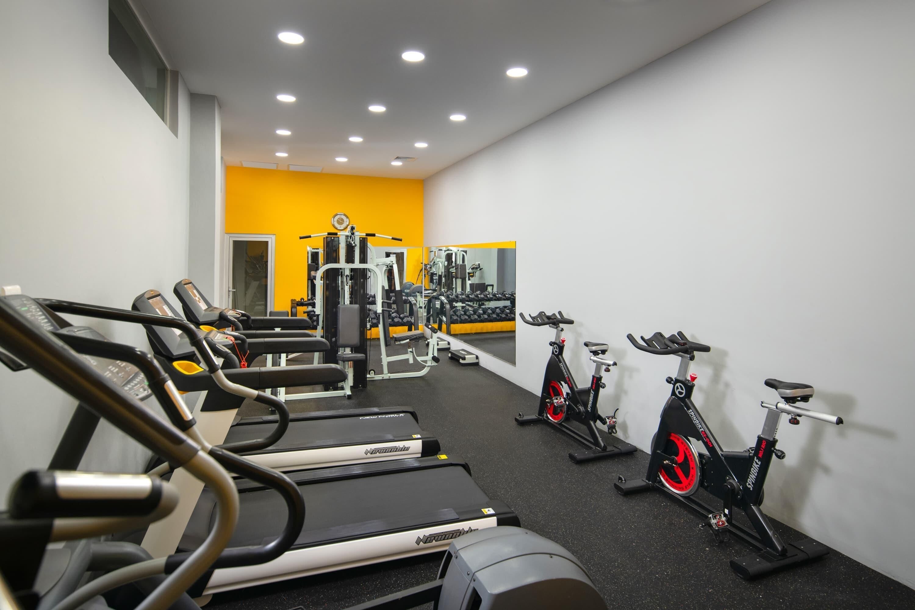 A gym with treadmills, stationary bikes, and weight machines.