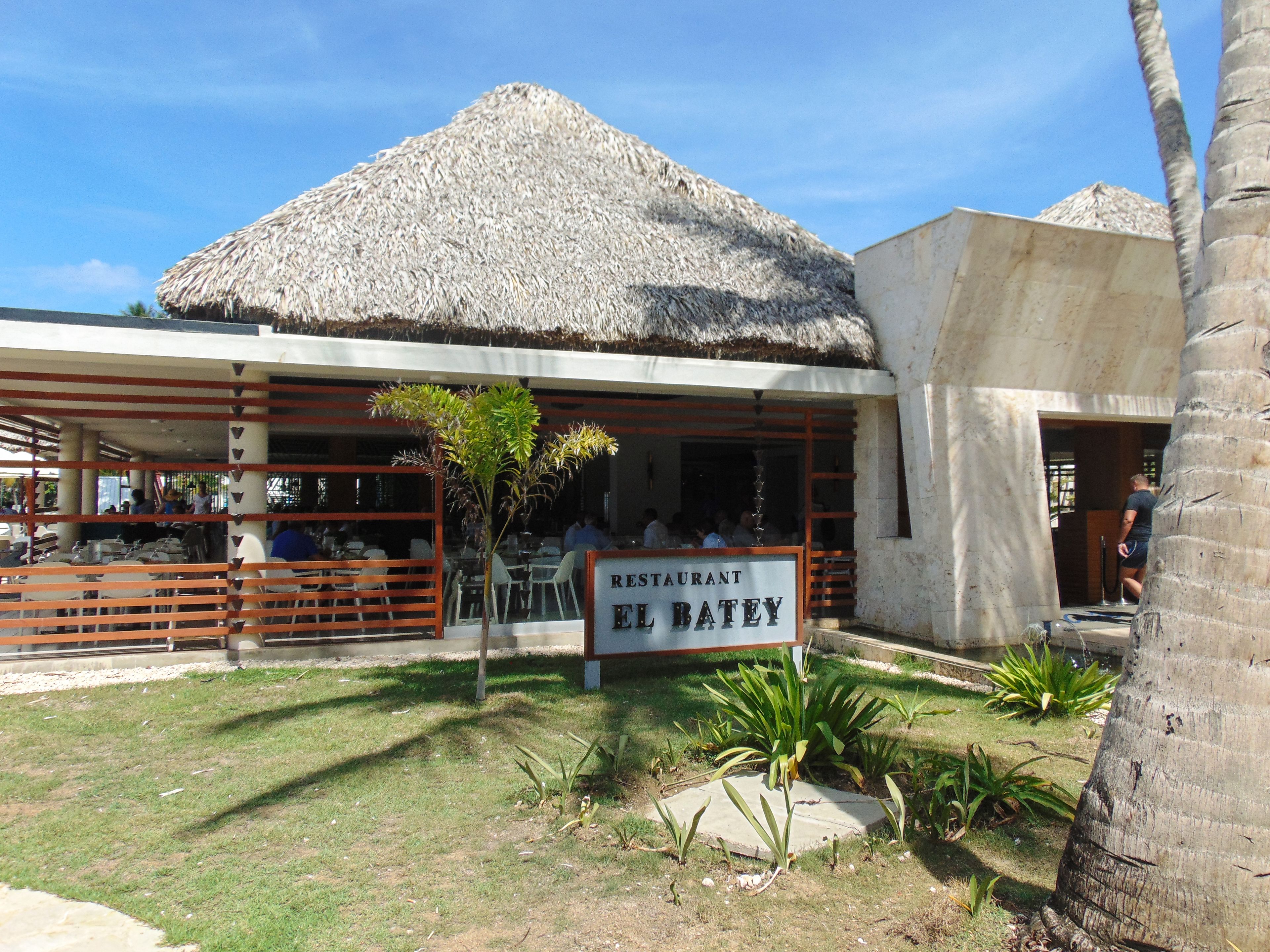 Un restaurante con techo de paja y un letrero que dice "RESTAURANT EL BATEY".