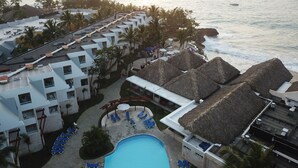 A resort with a swimming pool, lounge chairs, and thatched-roof structures. - Casa Marina Sosua, Trademark by Wyndham Resort (Sosúa)