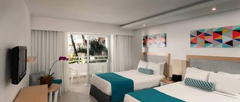A hotel room with two beds, a desk, a TV, and a balcony with a view of palm trees.