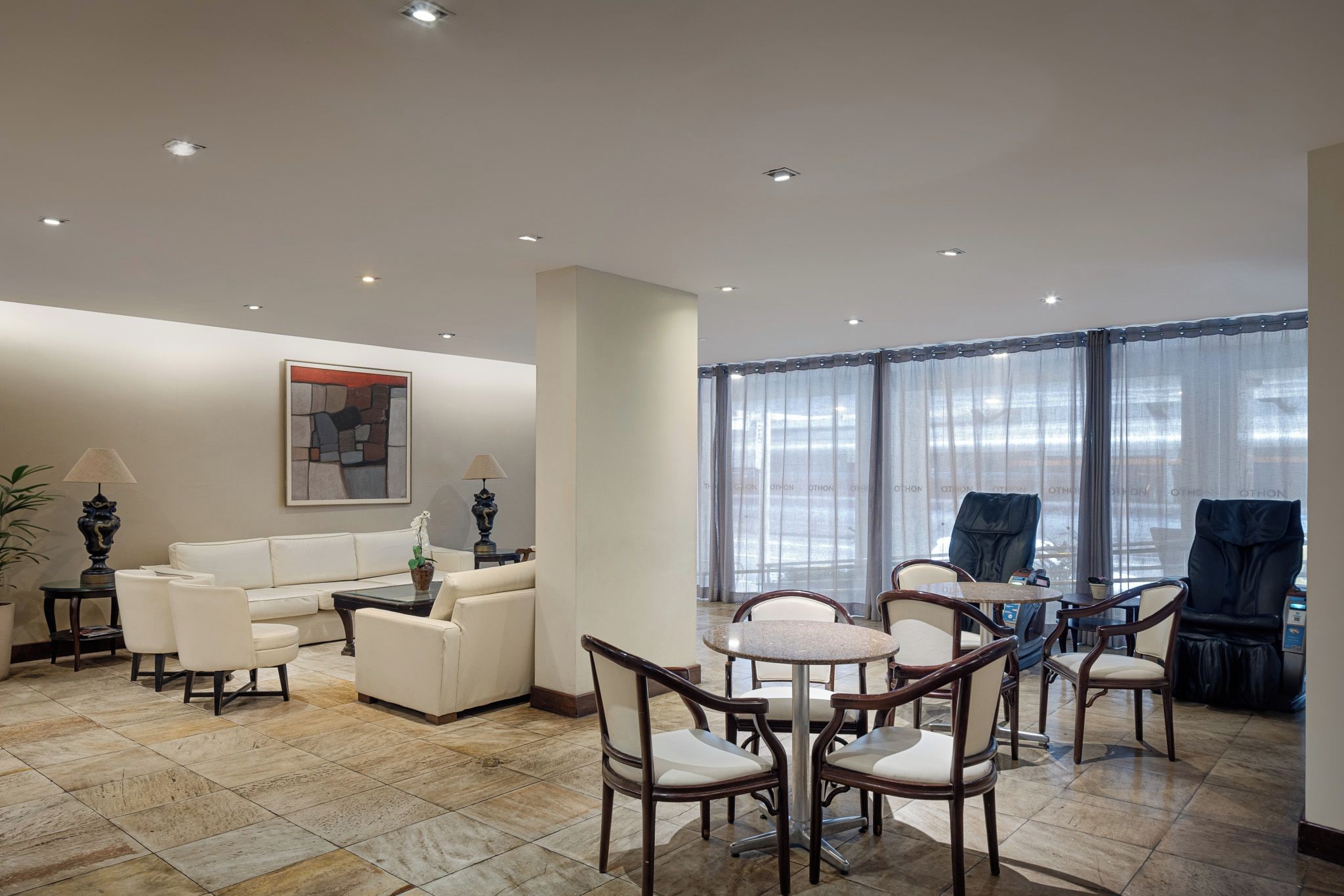 Un salon spacieux avec un canapé blanc, une table basse et un coin repas comprenant des chaises et une table.
