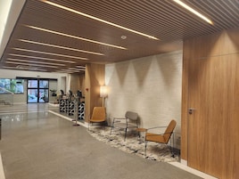 Un vestíbulo moderno con techo de madera, pared de ladrillo y mostrador de recepción.