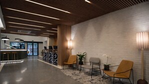 A modern lobby with a reception desk, seating area, and a brick wall. - Transamerica Executive Faria Lima (São Paulo)
