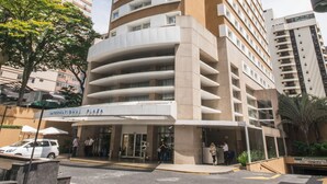 Un grand hôtel à la façade incurvée, doté de nombreux balcons et d’une enseigne indiquant « International Plaza ».