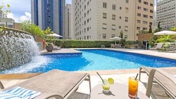 Una piscina al aire libre, tumbonas