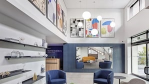 A modern lobby with seating, artwork, and a view of a staircase. - Transamerica Executive Bela Cintra (São Paulo)