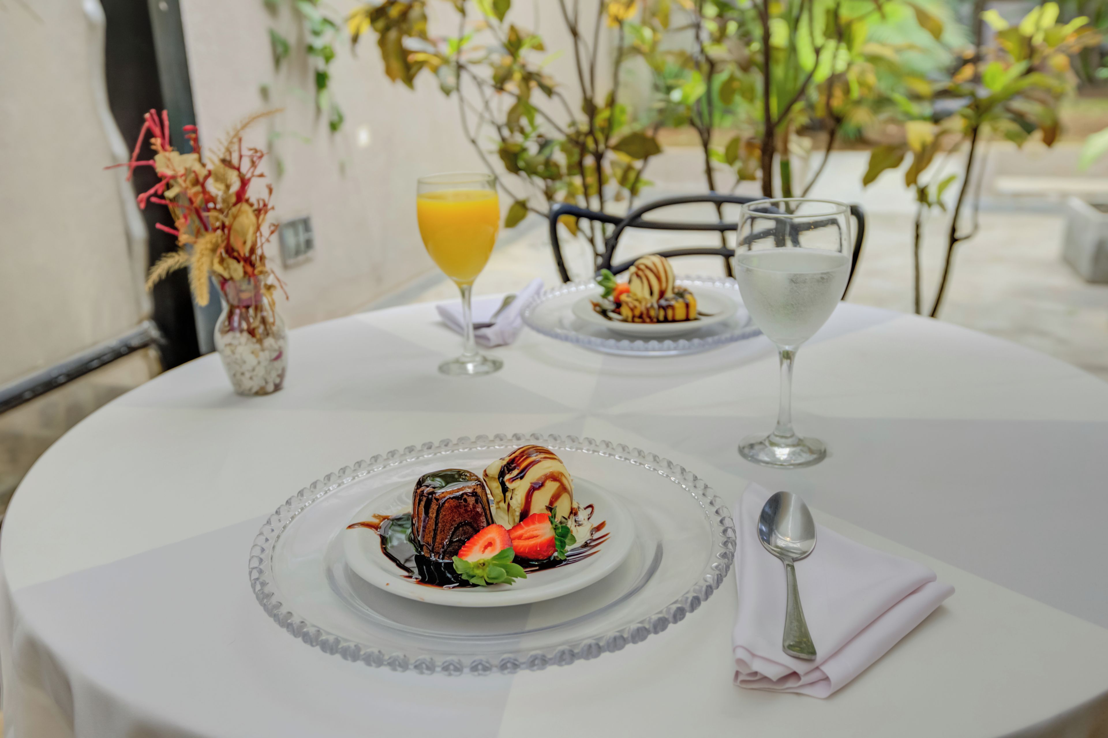 A table set with a dessert plate, a glass of orange juice, and a glass of water.